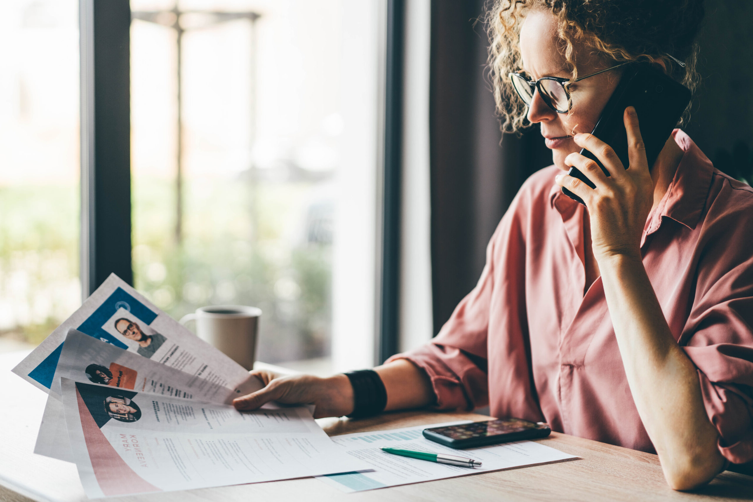 Managerin, die viele verschiedene Lebensläufe durchsieht und die perfekte Person auswählt.