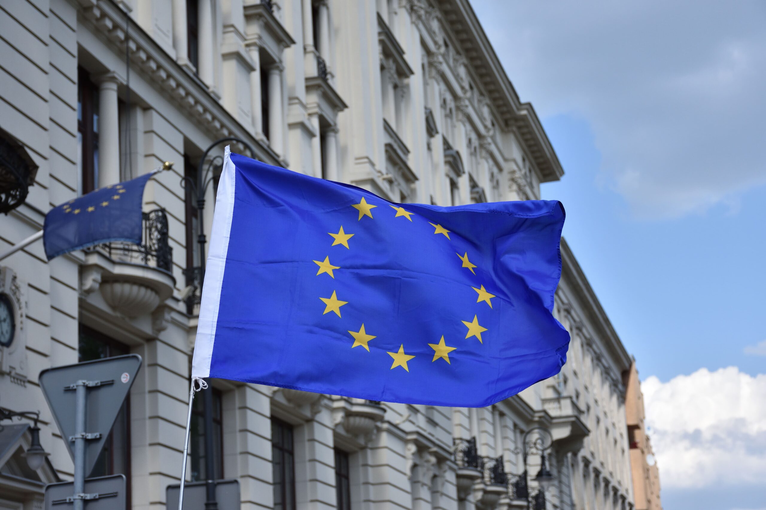 Flagge der EU vor einem beigen Regierungsgebäude